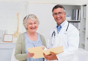 elder woman smiling with doctor beside